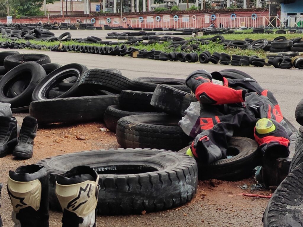Image of a go kart track with leathers and boots lying next to it.